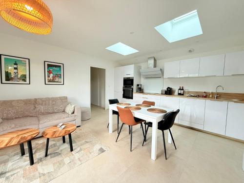 une cuisine et un salon avec un canapé et une table dans l'établissement Maison neuve à 300m de la plage pour 4 pers, St-Pierre-d'Oléron - FR-1-778-42, à Saint-Pierre-dʼOléron