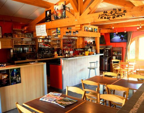 un bar dans un restaurant avec des tables et des chaises dans l'établissement Hôtel La Garenne, à Labeaume