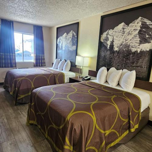 a hotel room with two beds and a window at Super 8 by Wyndham Denver Central in Denver