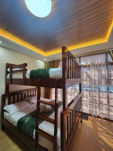 a room with two bunk beds and a ceiling at Summerville Hotel and Resort in Palayan City