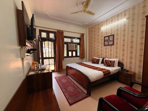Un dormitorio con una cama y una silla dentro. en Hotel Mandakini, en Rudraprayāg