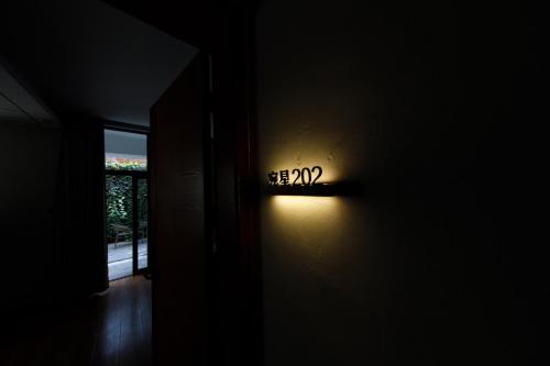 a light in a dark room with a sign on the wall at 慢境Slow Land半山海景花园酒店 in Dali
