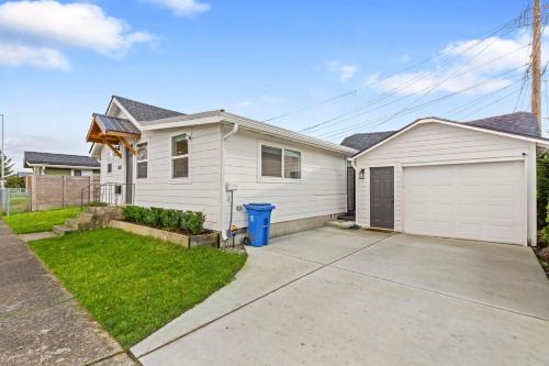 a white house with a garage and a driveway at Cozy Home 2br, 1ba with Portable AC - Pet Friendly in Tacoma