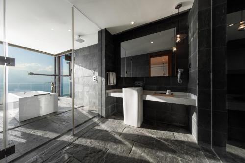 a bathroom with a tub and a sink and a mirror at 慢境Slow Land半山海景花园酒店 in Dali