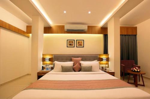 a bedroom with a large bed in a room at Hotel Samrat in Taliparamba