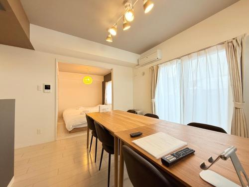 a room with a table and chairs and a bed at Sun Court Nango-dori サンコート南郷通 801 in Sapporo