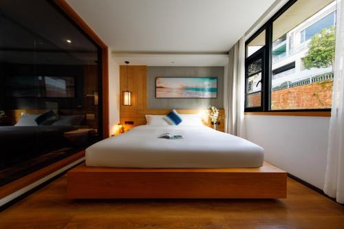 a bedroom with a large white bed and a window at 慢境Slow Land半山海景花园酒店 in Dali