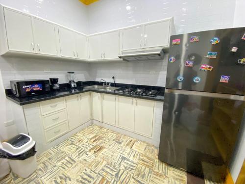 Colonial zone 3 bed 3 rooms balcony في سانتو دومينغو: مطبخ بخزائن بيضاء وثلاجة من الفولاذ المقاوم للصدأ