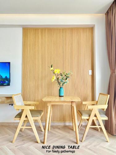 a dining room with a table with chairs and a vase of flowers at Luxury SeaView Apartment in 5 star Resort, An Bàng - Hội An in Dien Ban