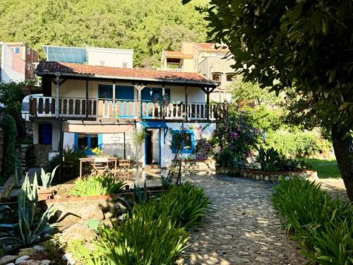 a house with a balcony and a yard at Charming Cozy Home on the Beach in Kaluđerac