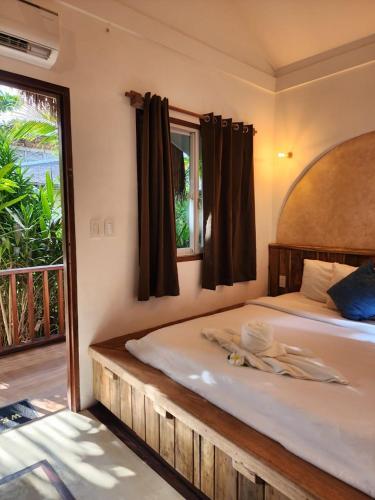 a bedroom with a large bed and a window at Prana Siargao Resort in General Luna