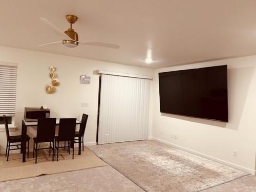 a living room with a table and a television on the wall at Entire Basement in Puyallup, WA in Puyallup