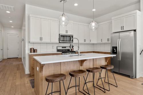a kitchen with white cabinets and a kitchen island with stools at Villa #15 at Bloomington Country Club Dog-Friendly townhouse in St. George