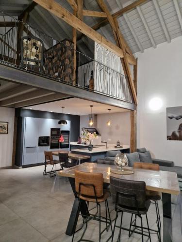 un salon avec une table et une mezzanine dans l'établissement Le Hameau des Coquelicots, à Damazan