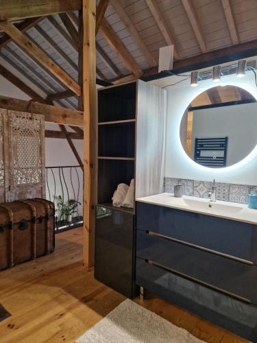 une salle de bain avec un lavabo et un miroir dans l'établissement Le Hameau des Coquelicots, à Damazan