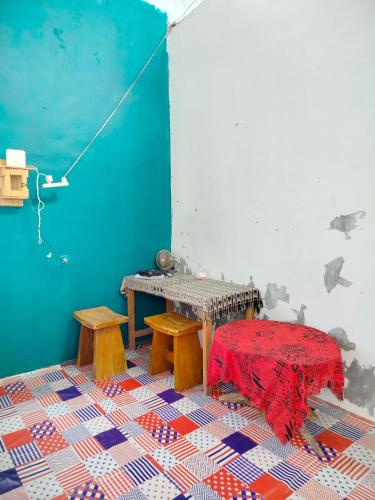 a room with a table and benches and a red blanket at Atta komodo homestay in Komodo