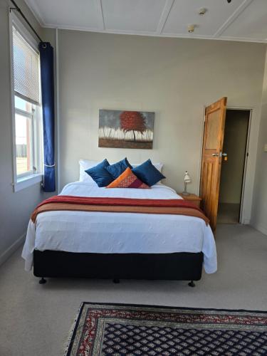 a bedroom with a large bed with blue pillows at Royal Accommodation in Stratford
