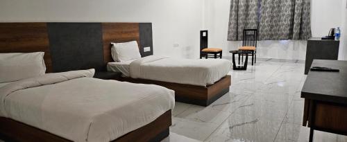 a hotel room with two beds and a desk at The Girvar Hotel, Barr in Beāwar