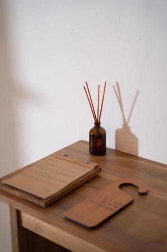 a wooden table with a cutting board and a vase with sticks at Green Hill Boutique Hotel in Labuan Bajo