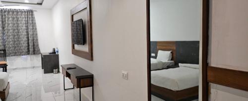 a room with a bedroom with a bed and a mirror at The Girvar Hotel, Barr in Beāwar