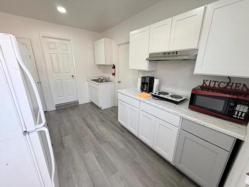 a kitchen with white cabinets and a microwave at Vegas Apt 8 Mins to The Strip - Free Parking in Las Vegas