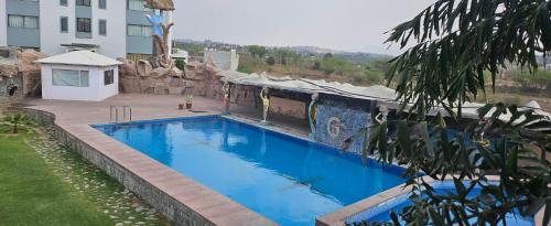 a large blue swimming pool next to a building at The Girvar Hotel, Barr in Beāwar