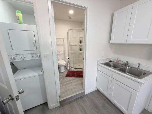 a white kitchen with a sink and a shower at Vegas Apt 8 Mins to The Strip - Free Parking in Las Vegas