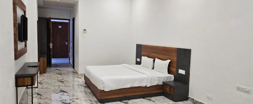 a bedroom with a bed and a television in it at The Girvar Hotel, Barr in Beāwar