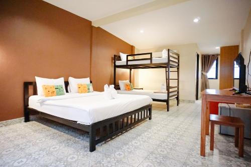 a bedroom with two beds and a bunk bed at Warmwell Hostel in Ban Chuk Kum