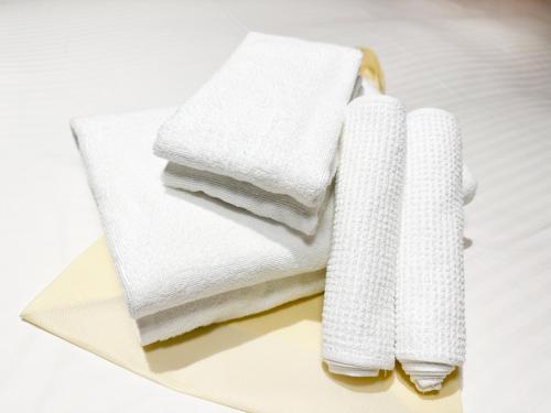 a pile of white towels sitting on a table at Shinsaibashi ARTY Inn in Osaka