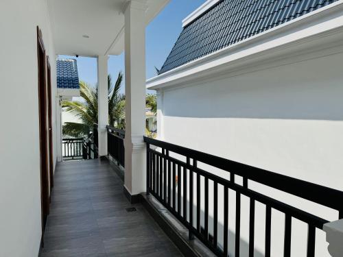 a balcony of a white house with a black railing at Ninh Chu 2 Hotel in Phan Rang