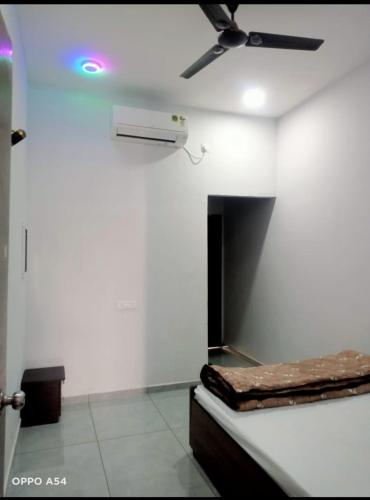 a room with a bed and a ceiling fan at JAI SWAMiNARAYAN DELUX HOMESTAY in Garudeshwar