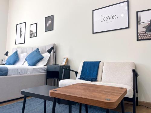 a living room with a couch and a table at Modern Renovated Studio Building 197 - 5 Min Walking from Metro and Pavilions in Dubai