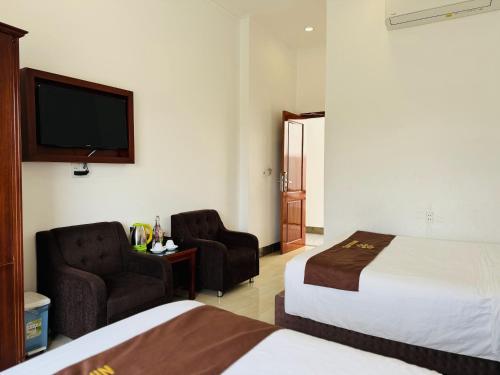 a hotel room with two beds and a flat screen tv at Ninh Chu 2 Hotel in Phan Rang