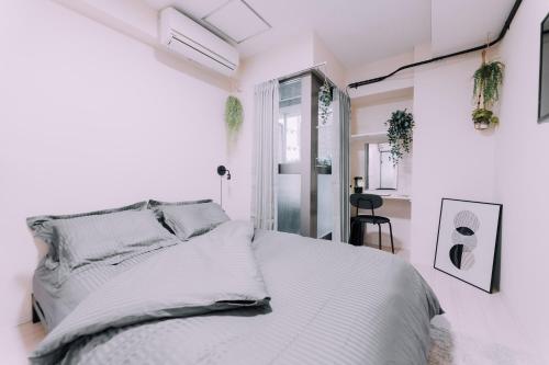 a white bedroom with a bed and a window at Minimalist Loft 5 Namba Compact Studio and Gym MA503 in Osaka