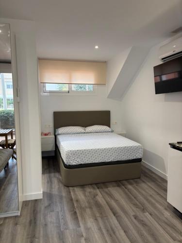 a bedroom with a bed and a wooden floor at Apartamentos Lofts Alamillo in Puerto de Mazarrón