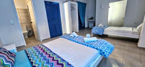 a bedroom with a large bed with blue and white sheets at Hotel Pleasure Black Beach Perissa Santorini in Perissa
