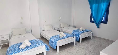 a room with three beds and a window at Hotel Pleasure Black Beach Perissa Santorini in Perissa