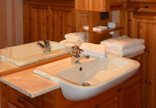 阿拉巴的住宿－Appartamento Sellaronda，浴室配有盥洗盆、镜子和毛巾