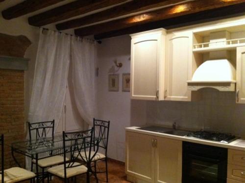 a kitchen with a table and chairs and a kitchen with white cabinets at La Castellana in Bergamo