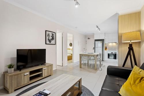 a living room with a flat screen tv and a couch at Yaran Suites in Rockingham
