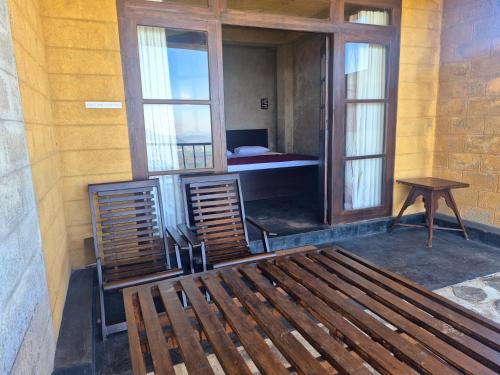 a room with a bench and a table and windows at Aroma Holiday Home-Haputhale in Haputale