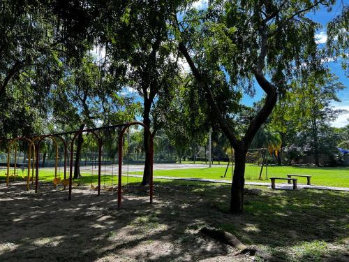 a park with a tree and a swing set at Private Room, 10 Min from Airport in San Pedro Sula
