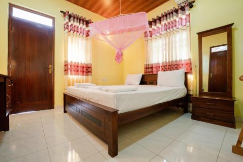 a bedroom with a large bed in a room at Suwani Pinnawala Homestay in Pinnawala