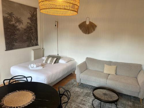 un salon avec un lit et un canapé dans l'établissement Beau studio au cœur de Dinard, à Dinard