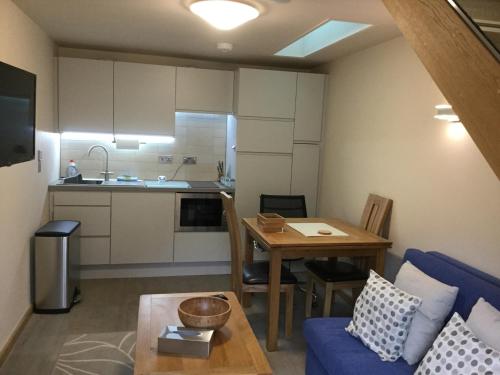ヨークにあるYork Aparthotelの小さなリビングルーム(テーブル付)、キッチンが備わります。