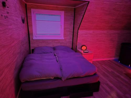 a bedroom with a purple bed and a window at Little Paradise Spa Appartement in Gummersbach