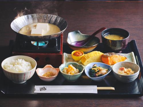 a tray with bowls of food and a pot of soup at Miyako Hotel Kyoto Hachijo in Kyoto