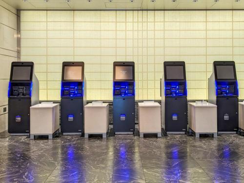 a row of ticket machines lined up against a wall at Miyako Hotel Kyoto Hachijo in Kyoto