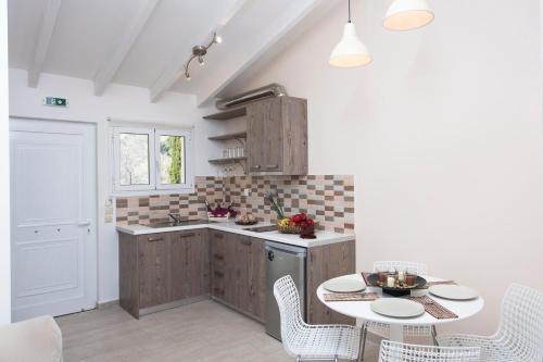 a kitchen with a table and chairs and a kitchen with a counter at Onar Corfu Aparts & Studios in Ýpsos